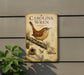 a metal sign with a bird illustration, mounted on a wall next to a plant.