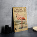 A vintage-style illustration of a pink flamingo standing in a body of water, with a map and other wildlife illustrations, is displayed on a wall.