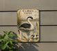 A vintage-style metal sign with a detailed illustration of a bird, likely a heron or egret, in a natural setting.