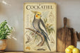 a vintage-style poster of a Cockatiel, a small parrot, displayed on a shelf next to a wooden cutting board and some lemons.