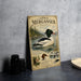 A vintage-style metal plaque featuring illustrations and text about the Common Merganser, a type of duck.