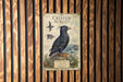 a poster of a crested auklet, a type of seabird, displayed on a wooden wall.