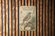 a vintage-style metal sign with a bird illustration, mounted on a wooden wall.