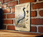 a vintage-style illustration of a crane, mounted on a brick wall.