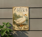 a vintage-style sign depicting a domestic duck, with a plant in the foreground.