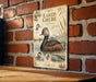 a vintage-style poster of a bird, specifically a duck, on a brick wall.