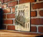 a vintage-style illustration of an Eastern Screech- Owl on a brick wall, accompanied by a detailed informational plaque.