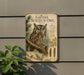 a metal plaque with an illustration of an Eastern Screech- Owl perched on a branch, surrounded by pine needles and leaves.
