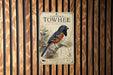 A vintage-style poster of a Towhee bird, a species of bird native to the eastern United States, is displayed on a wooden wall.