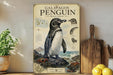 A vintage-style poster of a Galapagos penguin is displayed on a shelf, accompanied by a wooden cutting board and a potted plant.