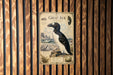 a vintage-style poster of a penguin, mounted on a wooden wall.