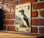 A vintage-style metal sign with illustrations and text, mounted on a brick wall.