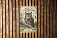 A poster of a Great Horned Owl is displayed on a wooden wall.