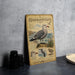 A metal plaque with illustrations and text about the Heermann's Gull, a seabird species, is displayed on a table.