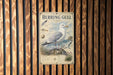a poster of a seagull, which is mounted on a wooden wall.
