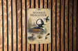 a poster of a hooded merican, a type of bird, displayed on a wooden wall.