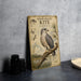 a metal sign with a detailed illustration of a Hook-Billed Kite, accompanied by text and a bird perched on a branch.