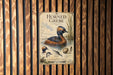 The image is a poster or sign featuring illustrations and text about the Horned Grebe, a type of water bird.