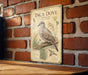 a vintage-style metal sign with an illustration of an Inca dove, mounted on a brick wall.