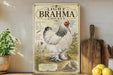 a vintage-style poster of a white and black Brahma chicken, which is a breed of chicken known for its distinctive appearance and gentle temperament. The poster is displayed on a wooden shelf, surrounded by various kitchen items such as a cutting board, a knife, and a bowl.
