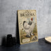 a vintage-style metal sign with a large illustration of a white and black chicken, placed on a table next to some black camera lenses.