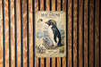a vintage-style poster of a macaroni penguin, with a detailed illustration of the penguin and its natural habitat.