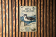 a vintage metal sign with a bird illustration, mounted on a wooden wall.