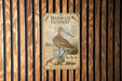a poster of a bird, specifically a marbled godwit, standing in a body of water.