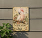 a vintage-style metal sign with a detailed illustration of a cockatoo perched on a branch, surrounded by various ornamental elements.