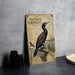 a vintage-style metal plaque with an illustration of a black bird perched on a branch, surrounded by text and a bird in flight.