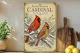 A vintage-style poster of two red cardinals perched on a snowy branch, with a wooden cutting board and a potted plant in the background.