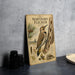 A vintage-style metal plaque featuring illustrations and text about the Northern Flicker, a bird species, is displayed on a table.