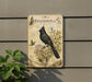 a detailed illustration of a black bird perched on a branch, surrounded by various plant life, including leaves and flowers.