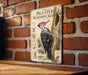 a vintage-style metal sign with illustrations and text, mounted on a brick wall.