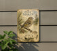 a vintage-style sign with illustrations of pine siskins, a type of small songbird, mounted on a wall.