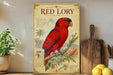 a large, colorful parrot, specifically a Red Lory, perched on a branch. The parrot is surrounded by various tropical plants and flowers, creating a vibrant and lush scene. The image is set against a backdrop of a white wall, with a wooden cutting board and a potted plant visible in the foreground.