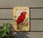 a vintage-style metal sign with a red parrot illustration, mounted on a wall next to a plant.
