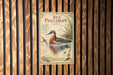 a vintage-style metal sign with a bird illustration, mounted on a wooden wall.