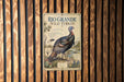 A vintage-style poster of a wild turkey is displayed on a wooden wall.