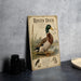 A metal sign featuring an illustration of a Rouen Duck standing on a grassy area with a bird in the background.