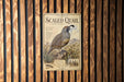 a vintage-style metal sign with a quail illustration, mounted on a wooden wall.