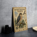 a vintage-style metal sign with illustrations and text about a sharp-shinned hawk, placed on a table next to some black camera lenses.