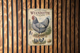 A vintage advertisement for Wyandotte chickens is displayed on a wooden wall.