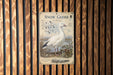 A metal sign with a white goose illustration is mounted on a wooden wall.