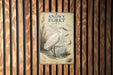 A vintage-style metal sign with a white egret illustration and text, mounted on a wooden wall.