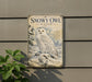 a vintage-style metal sign with a snowy owl illustration, mounted on a wall next to a plant.