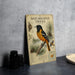 a metal sign with an illustration of a black and orange oriole perched on a pine branch, accompanied by text and a map.