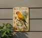 a vintage-style metal sign with a colorful illustration of a parrot, surrounded by various tropical plants and fruits.