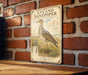 a vintage-style illustration of a bird, specifically the upland sandpiper, standing in a grassy field with flowers.