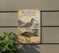 a vintage-style metal sign with a bird illustration, mounted on a wall next to a plant.
